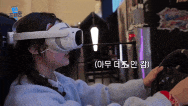 a girl wearing a virtual reality headset is playing a video game