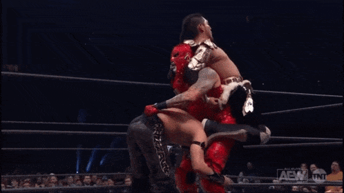 two wrestlers are wrestling in a ring with a sign that says aew