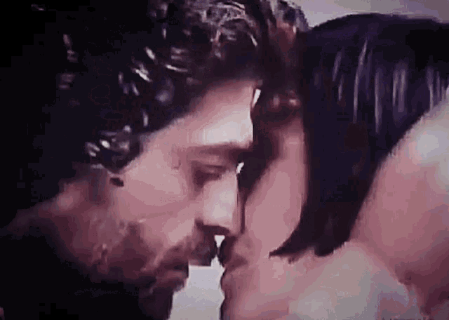 a man and a woman are kissing each other on the nose .