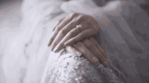 a close up of a bride 's hands with an engagement ring .