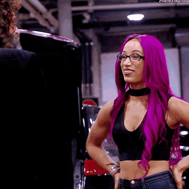 a woman with purple hair is wearing glasses and a black crop top