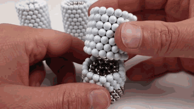 a person is holding a bunch of beads in their hand