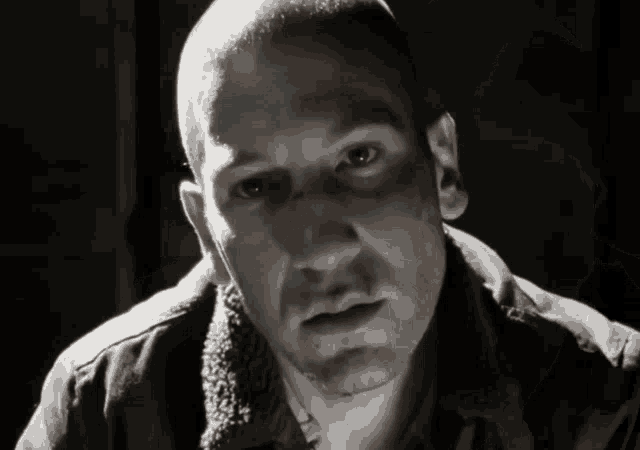 a close up of a man 's face with a black jacket on