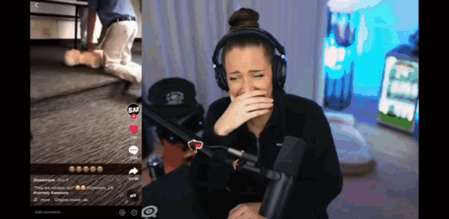 a woman wearing headphones is crying in front of a microphone and a screen that says sm