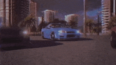 a blue car is driving down a street with palm trees in the background