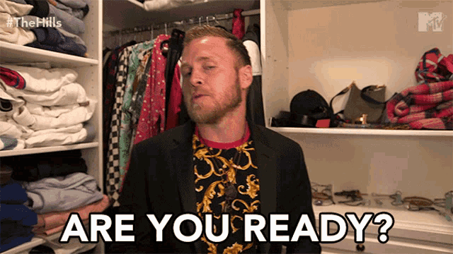 a man in a suit is standing in a closet and says are you ready