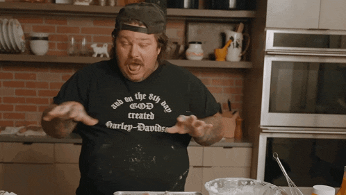 a man in a black shirt that says god created harley-davidson