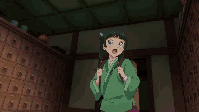 a girl in a green kimono is smiling with her hand on her chin