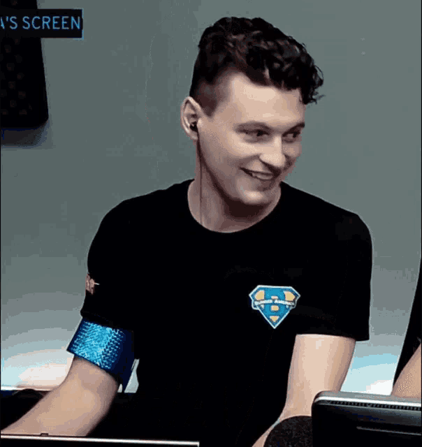 a man wearing ear buds and a black shirt with a superman logo on it