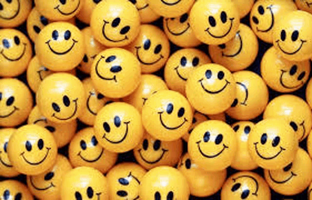 a pile of yellow smiley faces sitting on top of each other on a table .