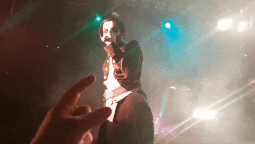 a person giving a middle finger to a singer on stage