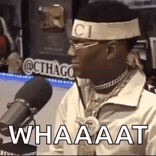 a man wearing a headband with the word gucci on it is talking into a microphone .