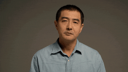 a man in a blue shirt is making a face