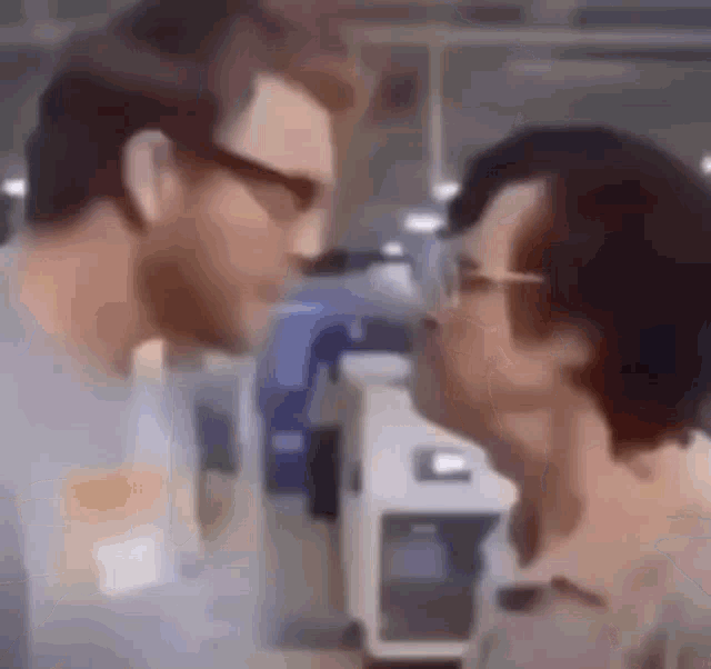 two men are kissing each other in a room in a blurry photo .