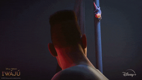 a man is standing in a dark room with a disney logo in the corner