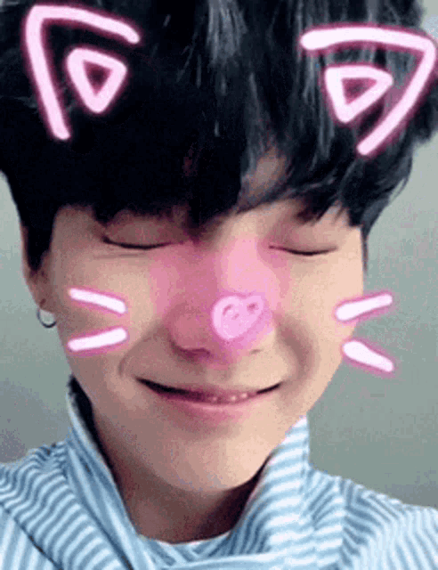 a close up of a person 's face with a pink nose and cat ears .
