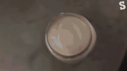 a mason jar with a donut on top of it and the letter s in the corner