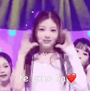a girl is dancing on a stage with a heart and the words `` te amo lia '' written on it .