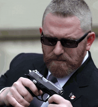 a man with a beard is holding a gun