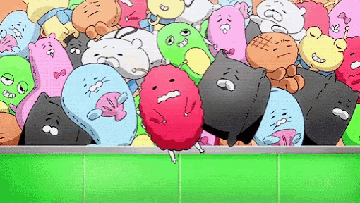 a bunch of stuffed animals are sitting on top of each other on a green surface .