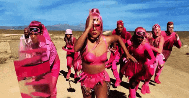 a woman in a pink outfit is surrounded by other women in pink outfits