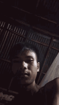 a man laying in a dark room with a metal ceiling