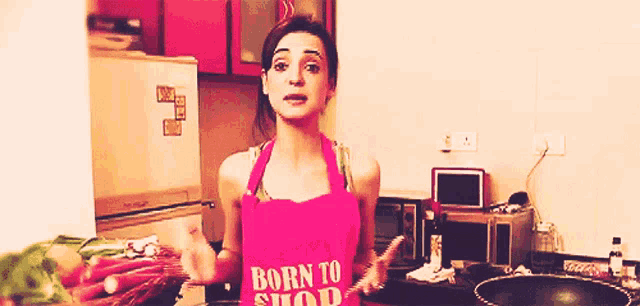 a woman in an apron that says born to shop