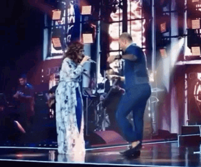 a man and a woman singing on a stage