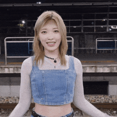a woman wearing a denim crop top and a necklace