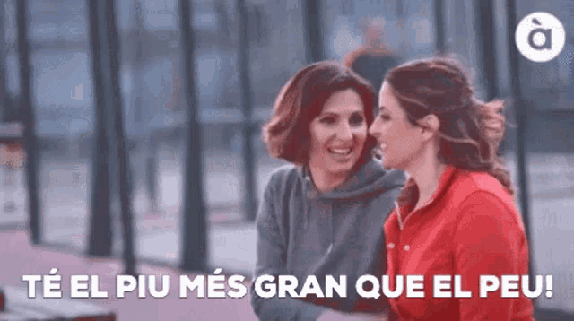 two women are sitting next to each other with the words te el piu mes gran que el peu