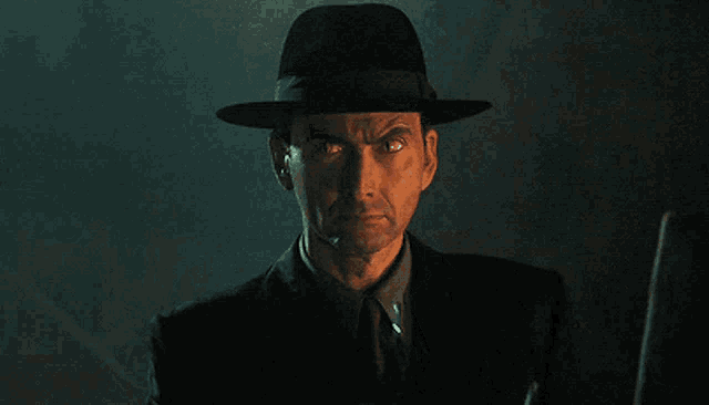 a man in a suit and hat is pointing at something