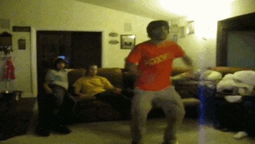a man in an orange shirt that says roxy is dancing