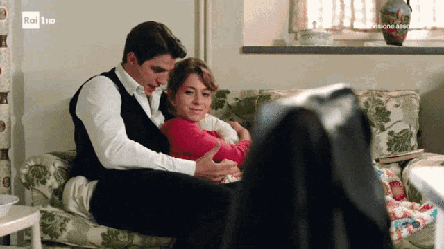 a man and woman are sitting on a couch with rai hd written on the bottom right