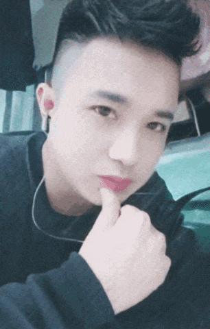 a young man with a shaved head is taking a selfie with his finger on his chin