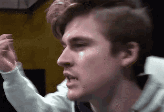 a close up of a man 's face with a white shirt on