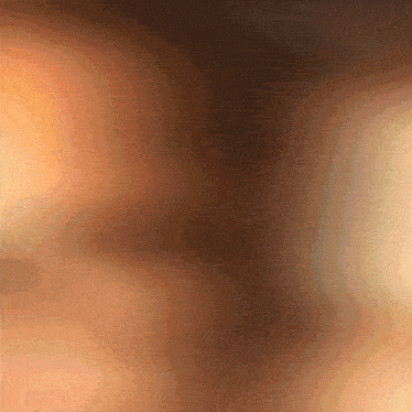 a blurred image of a person 's face with a brown background