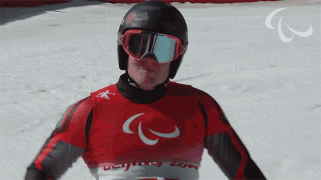 a man wearing a helmet and goggles has the letter c on his shirt