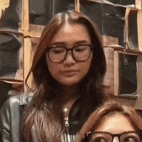 a woman wearing glasses is standing next to a woman wearing sunglasses