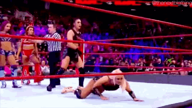 a woman is wrestling in a wrestling ring with a referee .