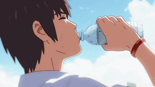 a person drinking water from a plastic bottle with a blue sky in the background