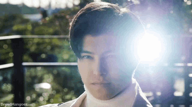 a close up of a man 's face with the sun shining on his face .