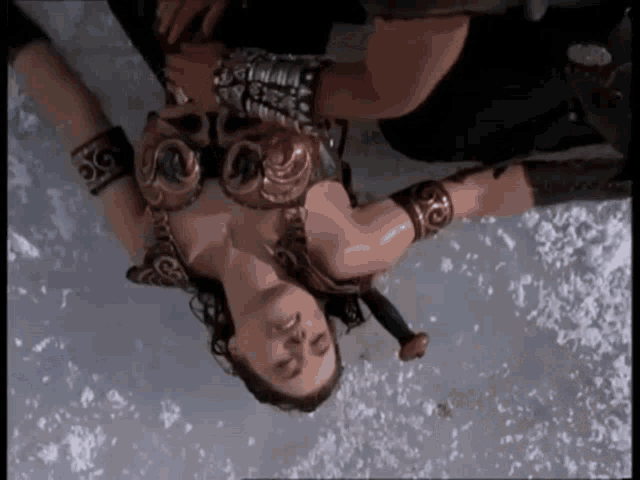 a woman laying on her back with a sword in her hand