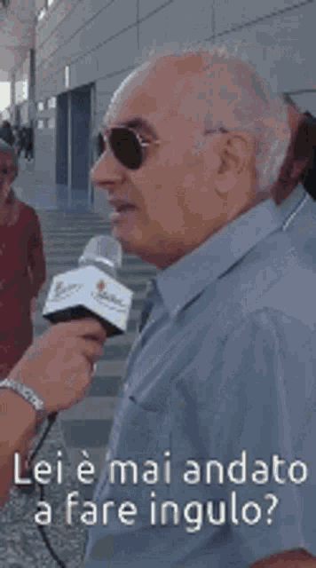 a man talking into a microphone with the words lei e mai andato a fare ingulo on the bottom