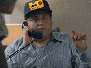 a man talking on a phone with a patch on his hat that says ' texas ' on it