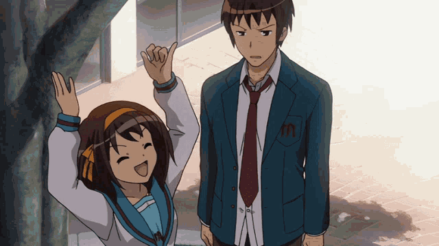 a boy and a girl are standing next to each other and the girl has the letter m on her jacket