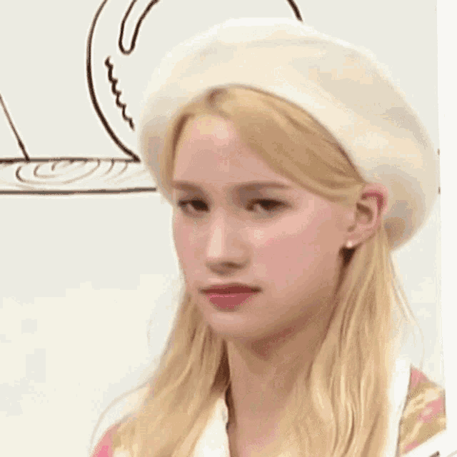 a close up of a woman wearing a white beret and making a funny face .