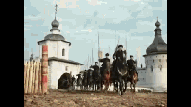 a group of men riding horses in front of a church .