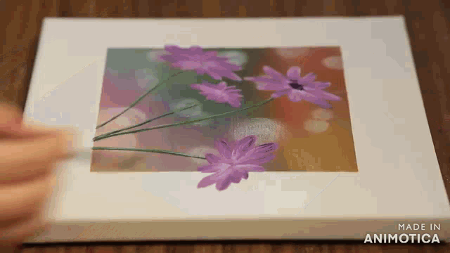 a person is painting purple flowers on a canvas made in animotica
