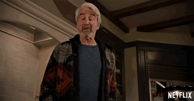 a man standing in a kitchen with a netflix advertisement in the background