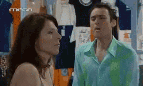 a man and a woman are standing next to each other in front of a store .